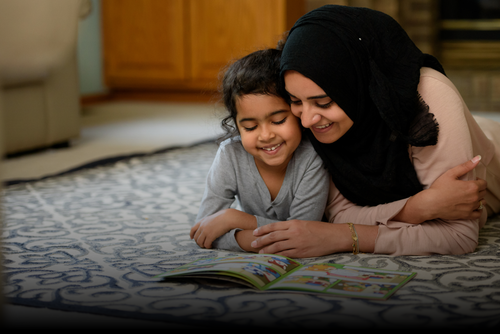 A mother and daughter reading a Noor Kids Islamic comic book together at home