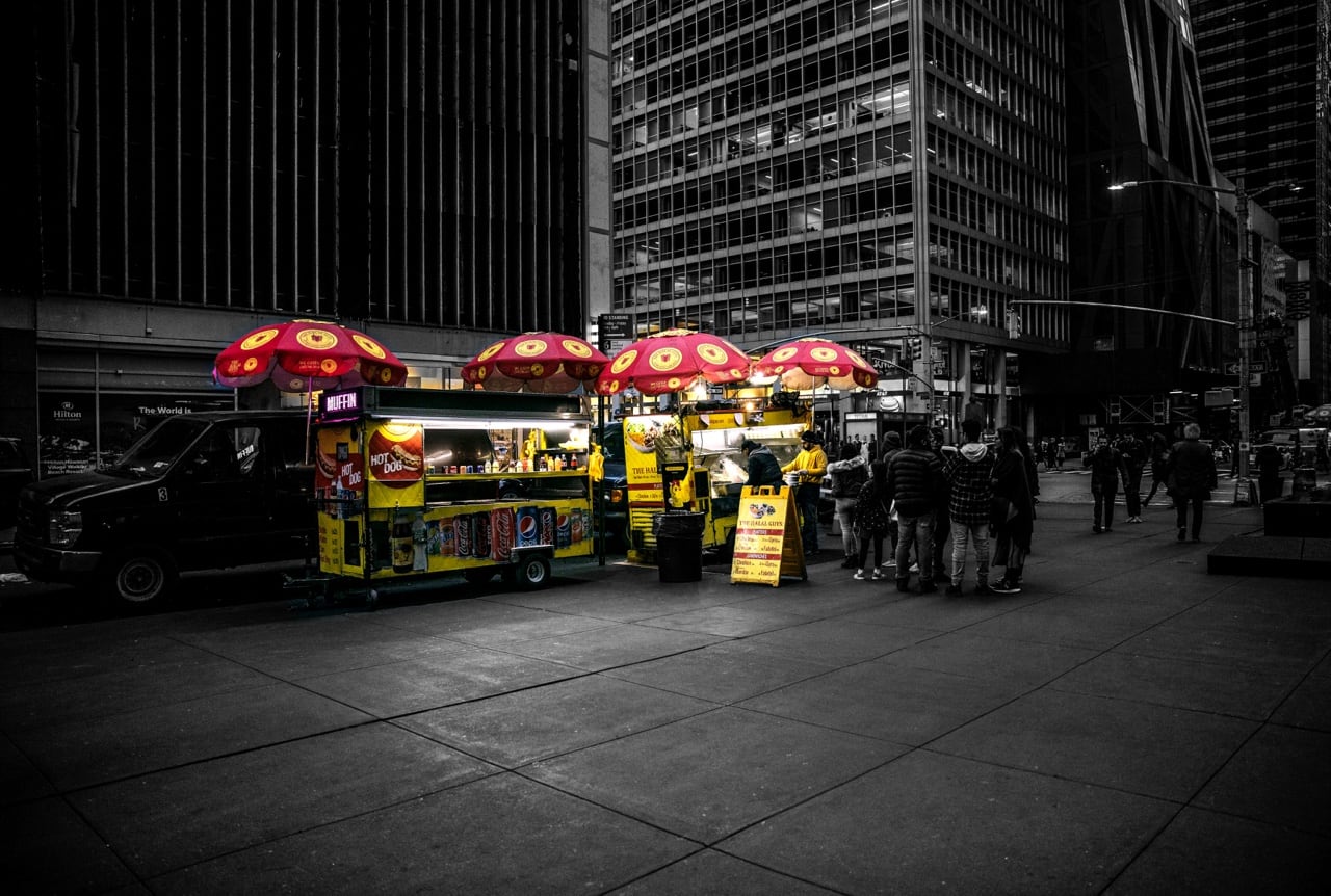 The original Halal Guys street cart with its yellow umbrellas in New York City