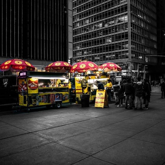 The original Halal Guys street cart with its yellow umbrellas in New York City