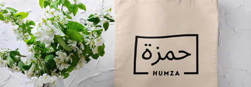 A personalized tote bag with a name printed in Arabic, a practical Umrah gift