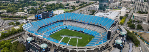 Aerial view of a wide NFL football stadium bowl on a sunny fall afternoon
