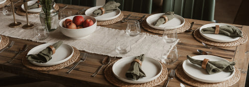 An elegantly set wooden dining table ready to welcome guests