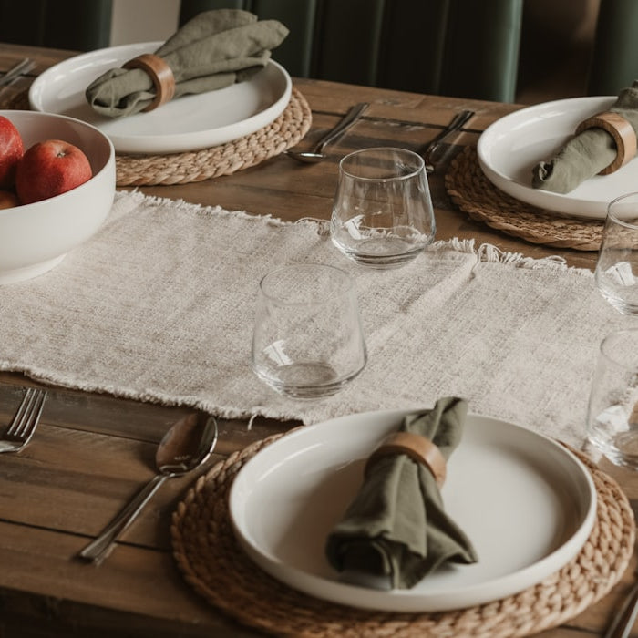 An elegantly set wooden dining table ready to welcome guests