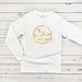 a white t - shirt with gold arabic lettering on it