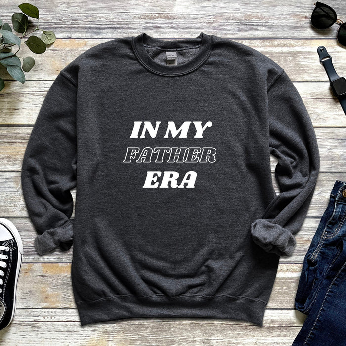 a sweater that says in my father era next to a pair of jeans