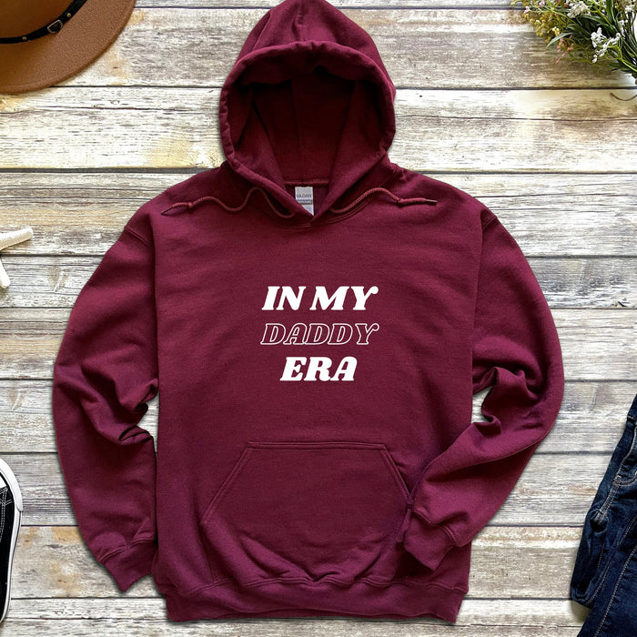 a maroon hoodie that says in my daddy era